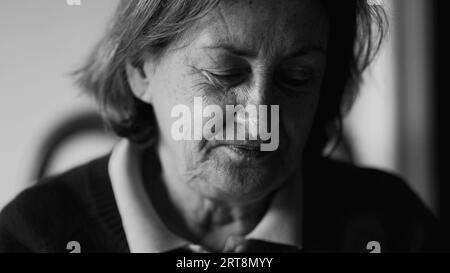 Pensive femme âgée gros plan visage en monochrome, dame âgée pensive dans les années 70 pensant en noir et blanc Banque D'Images