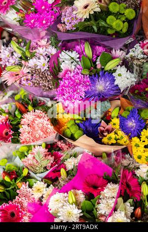 Les fleurs sont près d'un fleuriste dans une rue de la ville. De beaux bouquets de fleurs diverses sont présentés dans un fleuriste. Bouquets sur table, bousi fleuriste Banque D'Images