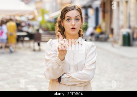 Mécontent mécontent jeune femme réagissant à une idée horrible désagréable, insatisfait de mauvaise qualité, main de vague, tête de secousse non, rejeter l'idée, ne pas aimer la proposition en plein air. Fille marchant dans la ville Sunshine Street Banque D'Images