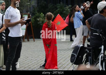 Anvers, Belgique. 11 septembre 2023. Une fille avec des drapeaux du Maroc assiste à un service commémoratif pour les victimes du tremblement de terre au Maroc, dans le centre d'Anvers, Belgique, le 11 septembre 2023. Crédit : Zheng Huansong/Xinhua/Alamy Live News Banque D'Images