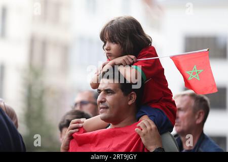 Anvers, Belgique. 11 septembre 2023. Des personnes portant des drapeaux du Maroc assistent à un service commémoratif pour les victimes du tremblement de terre au Maroc, dans le centre d’Anvers, en Belgique, le 11 septembre 2023. Crédit : Zheng Huansong/Xinhua/Alamy Live News Banque D'Images