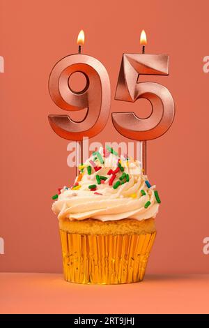 Gâteau d'anniversaire avec bougie numéro 95 - fond fusion corail Banque D'Images