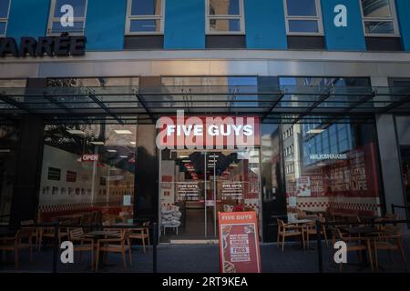 Photo d'un panneau avec le logo de cinq gars sur leur restaurant local dans le centre-ville de Dortmund, en Allemagne. Five Guys Enterprises, LLC est un américain rapide f Banque D'Images