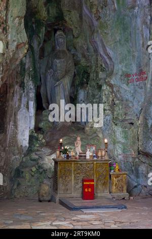 Petit sanctuaire devant une statue de Guanyin directement sculptée dans la pierre de marbre à l'entrée de la grotte de Huyen Khong à Da Nang. Banque D'Images