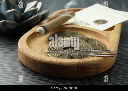 Aiguilles d'acupuncture, bâton de moxa et pièces chinoises antiques sur table en bois, gros plan Banque D'Images