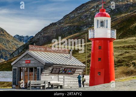 Deux personnes se tiennent devant le centre d'information Rheinquelle et le phare du col d'Oberalp, Gotthard Group, Graubünden, Suisse Banque D'Images