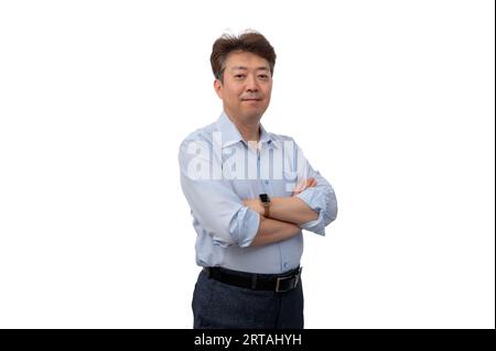 Portrait d'un homme d'affaires asiatique d'âge moyen dans ses années 50 portant une chemise bleue Banque D'Images