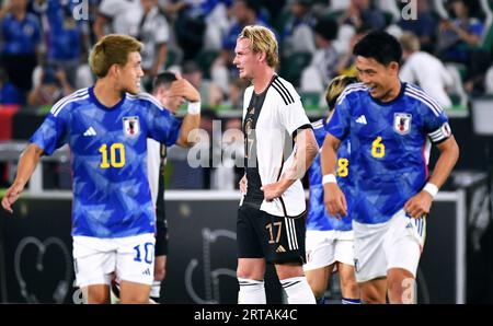 Fussball, Herren, Deutschland, Nationalmannschaft, LŠnderspiel, Volkswagen Arena Wolfsburg : Deutschland - Japon 1:4, Julian Brandt (GER) zwischen den jubelnden Ritsu Doan (JPN) und Wataru Endo (JPN). Jubel, Freude, Aktion, EnttŠuschung, Frust. LA RÉGLEMENTATION DFB INTERDIT TOUTE UTILISATION DE PHOTOGRAPHIES COMME SÉQUENCES D'IMAGES ET/OU QUASI-VIDÉO. Banque D'Images