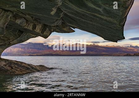 Vue sur les montagnes des Andes à travers une formation de marbre des Cuevas de Marmol dans le Lago General Carrera, Chili, Patagonie, Amérique du Sud Banque D'Images