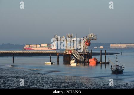 Warsash Maritime Academy Pier sur la rivière Hamble. Hampshire Royaume-Uni avec un porte-conteneurs quittant le port de Southampton. Banque D'Images