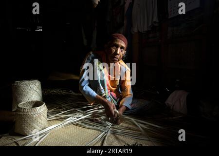 Koh Yao, Thaïlande ; 1 janvier 2023 : une femme âgée prépare un panier avec des feuilles de palmier séchées. Banque D'Images