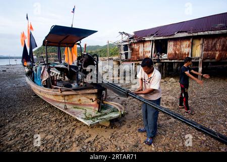 Koh Yao, Thaïlande ; 1 janvier 2023 : des pêcheurs réparent leurs bateaux à long Tail dans le village de pêcheurs de Koh Yao. Banque D'Images