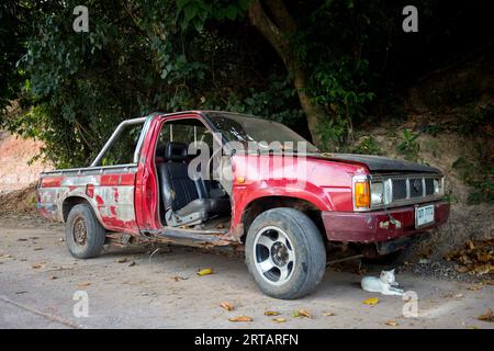 Koh Yao, Thaïlande ; 1 janvier 2023 : vieille voiture abandonnée sans porte rouge. Banque D'Images