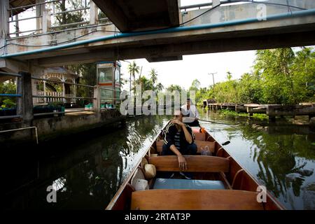 Amphawa, Thaïlande ; 1 janvier 2023 : un homme et une femme prennent un canoë à travers le marché flottant d'Amphawa. Banque D'Images