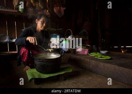 Chiang Rai, Thaïlande ; 1 janvier 2023 : une femme d'une tribu indigène des hautes montagnes du district de Chiang Rai cuisine chez elle. Banque D'Images