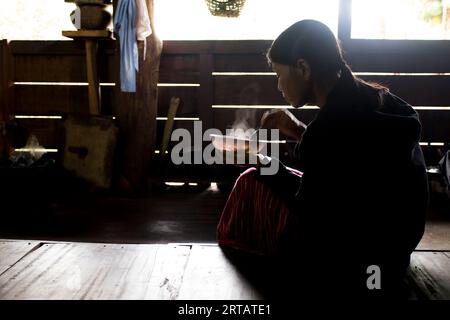 Chiang Rai, Thaïlande ; 1 janvier 2023 : une femme d'une tribu indigène des hautes montagnes du district de Chiang Rai cuisine chez elle. Banque D'Images