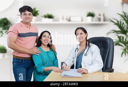 Portrait de médecin gynécologue indienne consultant de jeunes couples mariés patients en clinique de fertilité au sujet de la FIV ou IUI. Planification de la grossesse Banque D'Images