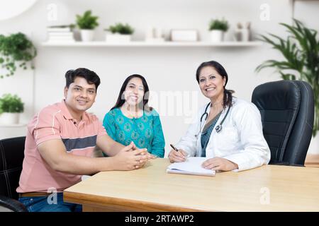 Portrait de médecin gynécologue indienne consultant de jeunes couples mariés patients en clinique de fertilité au sujet de la FIV ou IUI. Planification de la grossesse Banque D'Images