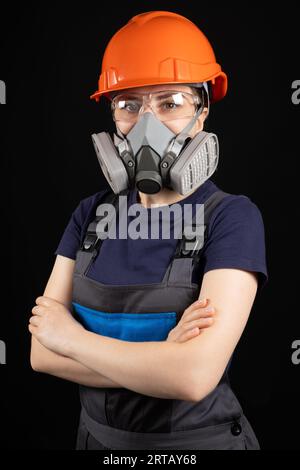 Une femme portant un casque, un respirateur et des lunettes sur fond noir Banque D'Images