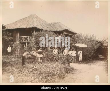 Colonialisme européen en Indonésie, 1900, 1890, homme européen devant sa maison avec des serviteurs, probablement Langkat, Sumatra Banque D'Images