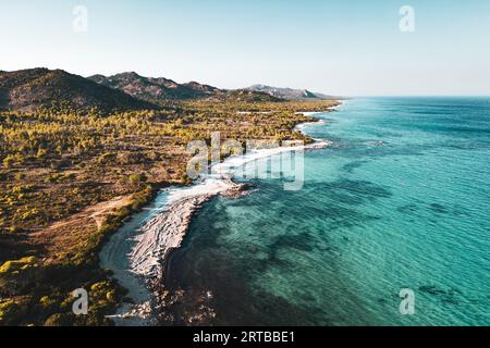 ITALIE, SARDAIGNE 2023 : vue aérienne de la célèbre oasis de Biderosa. Une belle forêt de pins d'Alep et de pins de pierre ainsi qu'une riche végétation spontanée composent la forêt côtière de Bidderosa. Encadré par des genévriers, des chênes-lièges et des chênes verts, un paradis de carte postale s’ouvre, l’un des rares en nombre limité en Sardaigne, avec les couleurs émeraude de la mer et le blanc pur du sable fin. Banque D'Images