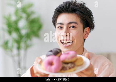 Homme japonais mangeant à la maison Banque D'Images