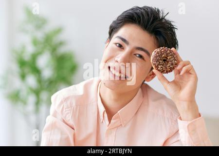 Homme japonais mangeant à la maison Banque D'Images