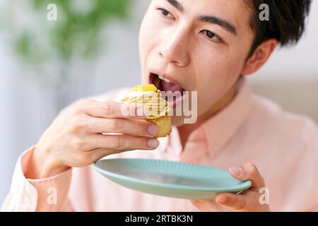 Homme japonais mangeant à la maison Banque D'Images