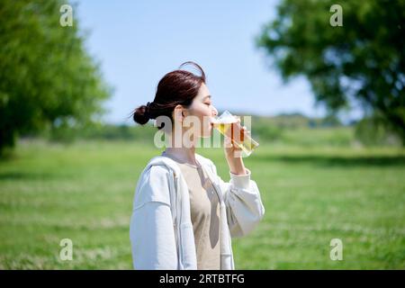 Femme japonaise buvant de la bière Banque D'Images