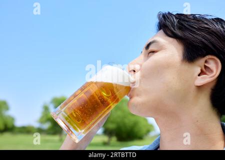 Homme japonais buvant de la bière Banque D'Images