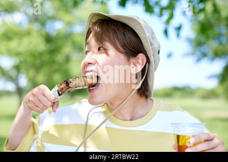 Homme japonais ayant barbecue au parc de la ville Banque D'Images