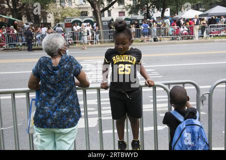 Spectateurs le long de Eastern Parkway à la West Indian Caribbean Parade annuelle le jour du travail à Brooklyn, New York. Grand-mère et enfants attendent le défilé. Banque D'Images