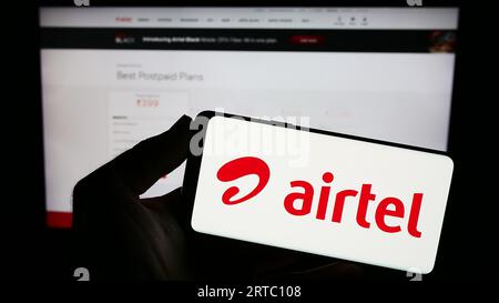 Personne tenant smartphone avec le logo de la société de télécommunications Bharti Airtel Limited sur l'écran en face du site Web. Concentrez-vous sur l'affichage du téléphone. Banque D'Images