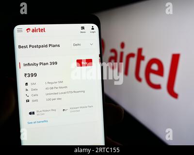 Personne tenant le smartphone avec la page Web de la société de télécommunications Bharti Airtel Limited sur l'écran avec logo. Concentrez-vous sur le centre de l'écran du téléphone. Banque D'Images