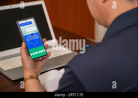 Un homme utilisant des services vocaux IA sur un appareil mobile. concept d'intelligence artificielle Banque D'Images