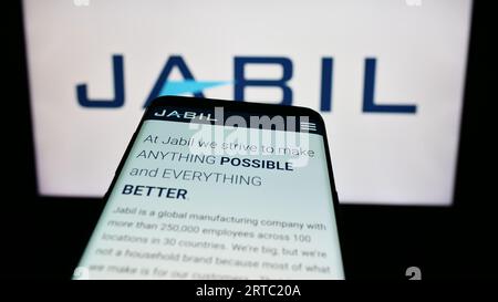 Téléphone mobile avec le site Web de la société électronique américaine Jabil Inc. Sur l'écran devant le logo de l'entreprise. Effectuez le focus sur le coin supérieur gauche de l'écran du téléphone. Banque D'Images
