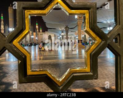Medina, Arabie Saoudite - 22 août 2023 : des pèlerins marchent sous des parapluies géants dans l'enceinte de la mosquée Nabawi. Auvents à Masjid Nabawi à Médine, en Arabie saoudite Banque D'Images