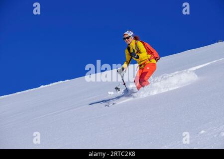 Femme sur la randonnée de ski descend de Wiedersberger Horn, Wiedersberger Horn, Alpes de Kitzbühel, Tyrol, Autriche Banque D'Images