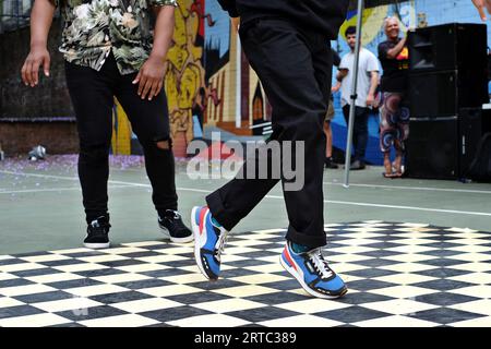 Happy Feet foot Work STEP en Blue Pumas et Black Jeans, jambes seulement - performances de breakdancing, batailles Hip Hop sur les courts de Woolloomooloo Banque D'Images