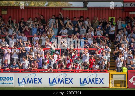 Les fans de football chantent, chantent et célèbrent sur la terrasse debout du Lower League Ground, stade Lamex, stade du Stevenage FC Banque D'Images