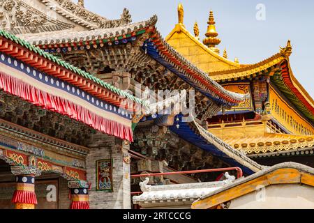 Ornements et figures sur le toit et la façade du monastère tibétain Kumbum Champa Ling, Xining, Chine Banque D'Images