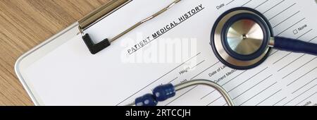 Stéthoscope et pilules médicales sur le formulaire vierge de l'historique médical du patient épinglé à la planchette à pince. Banque D'Images