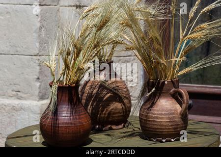 Trois pots en céramique avec des épillets, support de maïs sur le rebord de la fenêtre. Banque D'Images