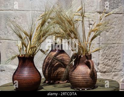 Trois pots en céramique avec des épillets, support de maïs sur le rebord de la fenêtre. Banque D'Images