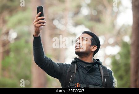 Téléphone, connexion et homme dans la nature pour la randonnée, le trekking et l'exercice dans les bois. Fitness, voyage et personne sur smartphone perdu sans signal pour GPS Banque D'Images