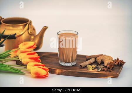 Thé indien masala chai. Masala chai thé épicé avec du lait et des épices ou karak chai ou chai de coupe. Masala thé en verre avec décoration, isolé. Banque D'Images