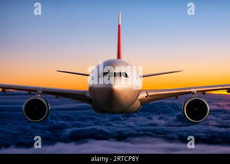 Vue de face de l'avion de ligne de passagers à corps large vole dans le ciel du lever du soleil Banque D'Images