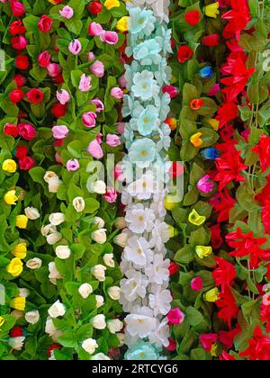 Fleurs artificielles multicolores utilisées pour la décoration du festival Diwali, accrochées à l'intérieur d'une boutique, la veille du festival Diwali et Ganesh Banque D'Images