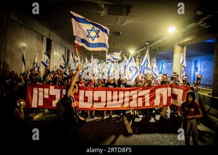 Jérusalem, Israël. 11 septembre 2023. Des manifestants défilent en brandissant des drapeaux israéliens et une banderole qui dit en hébreu "la cour est suprême" lors d'une manifestation à Jérusalem. Des milliers de manifestants anti-gouvernementaux israéliens se sont rassemblés devant la Cour suprême lundi, à la veille d'une audience historique sur une tentative de la coalition du Premier ministre Benjamin Netanyahu de restreindre les pouvoirs de la Cour. Crédit : SOPA Images Limited/Alamy Live News Banque D'Images