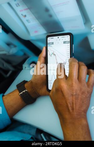 Homme vérifiant le marché forex sur smartphone. Application de téléphone mobile. Finance Exchange et trading. Trader en utilisant smartphone avec des inves boursières Banque D'Images